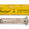 سرنگ شیشه‌ای قدیمی راکت لندن Rocket of London ساخت ایتالیا ظرفیت ۲ میلی‌لیتر با پیستون شیشه‌ای، اتصال فلزی و جعبه زرد اصلی