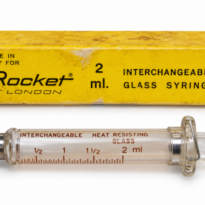 سرنگ شیشه‌ای قدیمی راکت لندن Rocket of London ساخت ایتالیا ظرفیت ۲ میلی‌لیتر با پیستون شیشه‌ای، اتصال فلزی و جعبه زرد اصلی